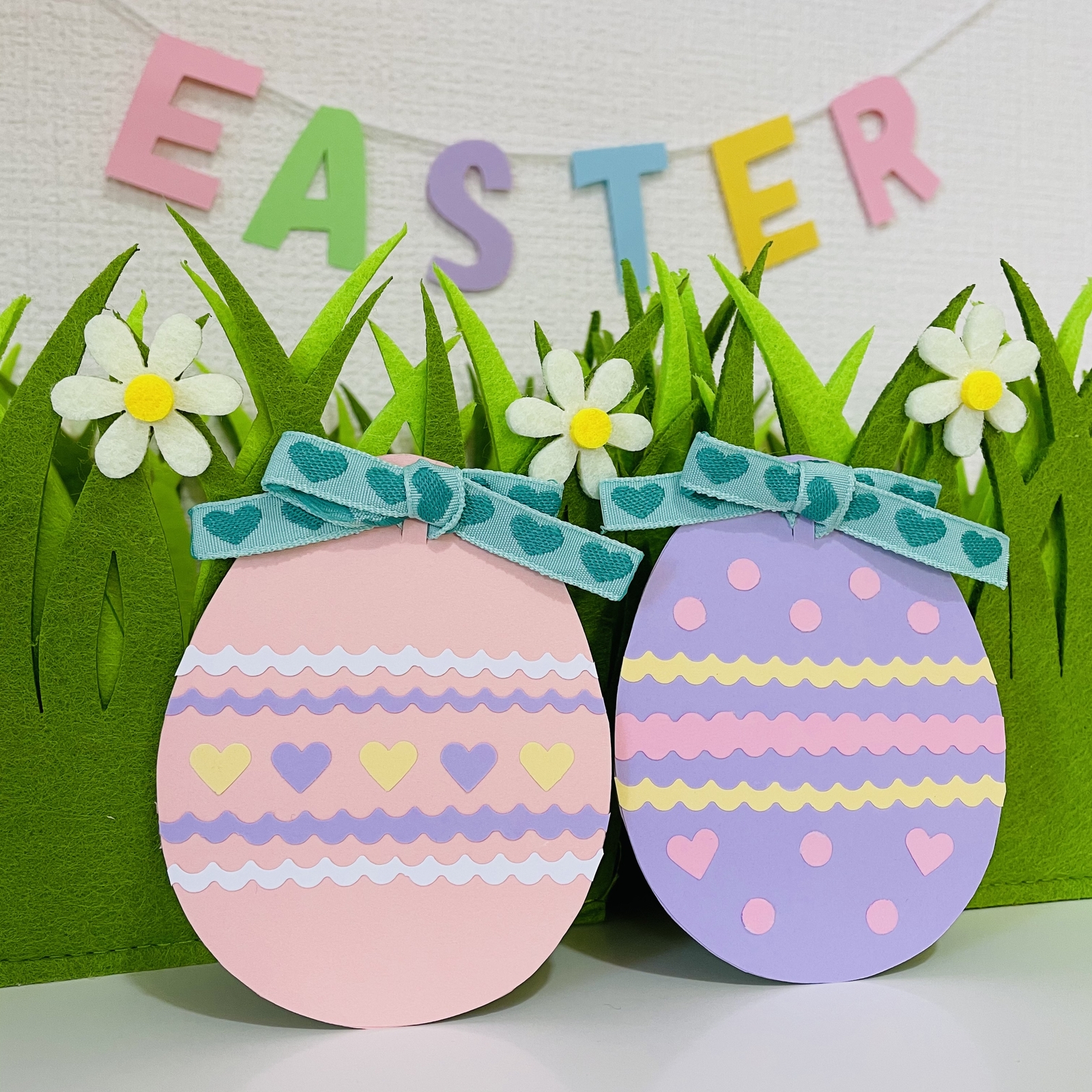 DIYイースターガーランドバニー、青い背景に多色紙で作られた文字EASTERの旗。ギフトのアイデア、装飾春、イースター。ステップバイステップ。トップビュー。プロセス子供の工芸品。手作り。の写真素材・画像素材 Image 117727138