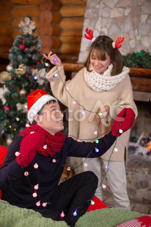 クリスマスツリーを飾り付けるカップル 10178000840 の写真・イラスト素材アマナイメージズ