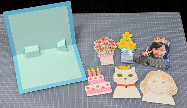 👇詳細はこちら👇『手作りで心を込めて🎨 アートな誕生日カード』, 開くと立体バースデーケーキが出てくる！, 絶対喜ばれる❤ポップアップカードの作り方はこちら🎉, 材料, ◻色紙 , ◻白画用紙, ◻定規、鉛筆, ◻はさみ, ◻のり, ◻カラーペン, ◻綿棒, ◻水,作り方, ①色紙を2つ折りにして、長さが異なる切り込みを3本入れる, ②色紙の切り込みを立ち上げて、同じ大きさの色紙をのりで貼る,