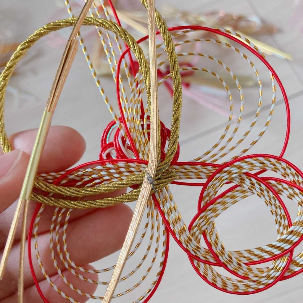 本組み開始 水引リースの下準備が完成し、 リースの本組みが始まる時は、 土台と水引きのバランスを見ながら製作します！この作品は背景はご祝儀袋でカラフルに、 水引きの個数も多かったためかなり華やかな印象です✨ リースはグラデーションにするのか、 色や形関係