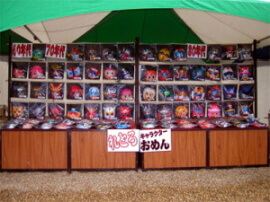 お祭りの屋台のお面屋の前にいる浴衣を着ている女性の写真・画像素材-Snapmart スナップマート