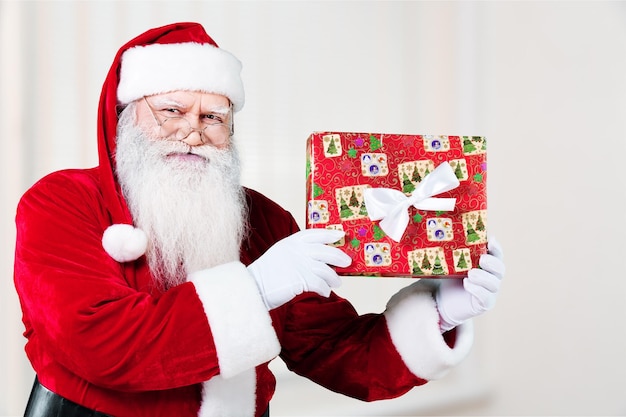 本物の本物の驚きのサンタクロースサンタはクリスマスプレゼントを差し出します。欲望の実現。Premium写真