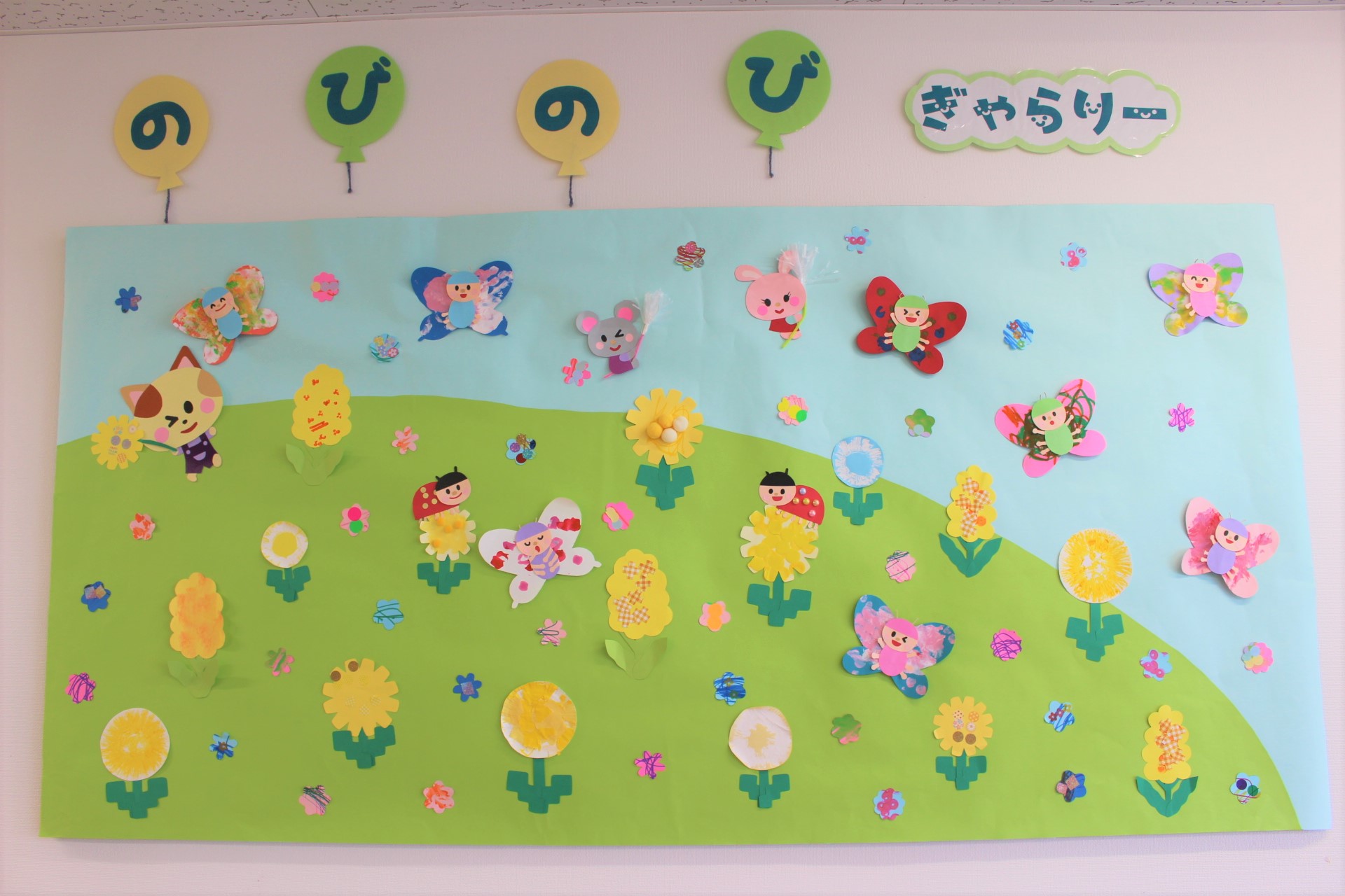壁面飾り 春 かわいいお花 壁面飾りとしても、お誕生日表にも 春の壁面『柄入り色紙でかわいい！たんぽぽ畑と春の虫さんたち』イラストレーターイシグロフミカnowanowanかわいい保育のイラスト・ 壁面