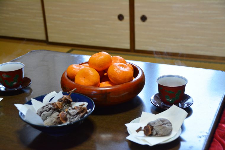 こたつでミカンを食べるカップル 11017013801 の写真・イラスト素材アマナイメージズ