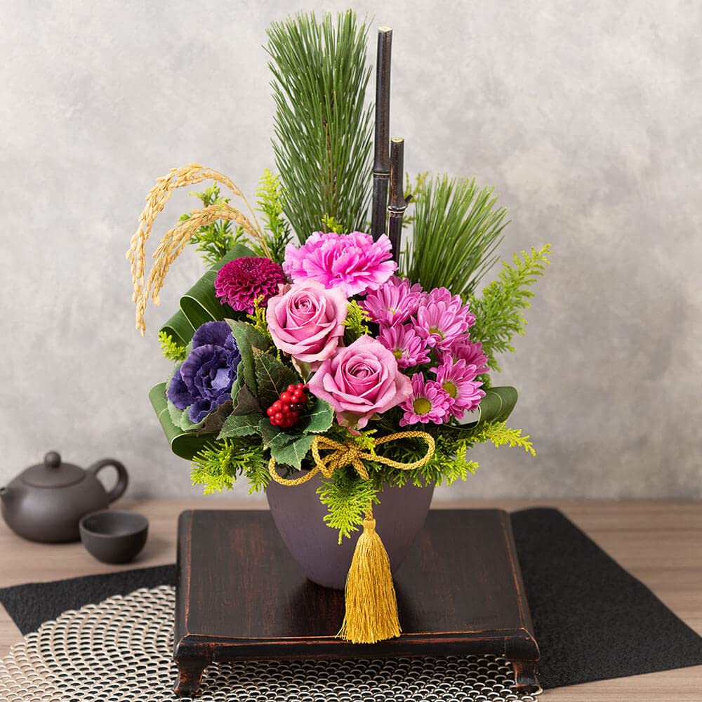 Amazonお正月 アレンジメントイイハナ・ドットコム紫 ゆかり の花飾り フラワーギフト 花ギフト プレゼント お祝い 生花 若松 千両バラ ピンポンマム カーネーション スプレーマム ドラセナ ヒバ 稲穂 葉ボタン 黒竹フラワーアレンジメント オンライン通販